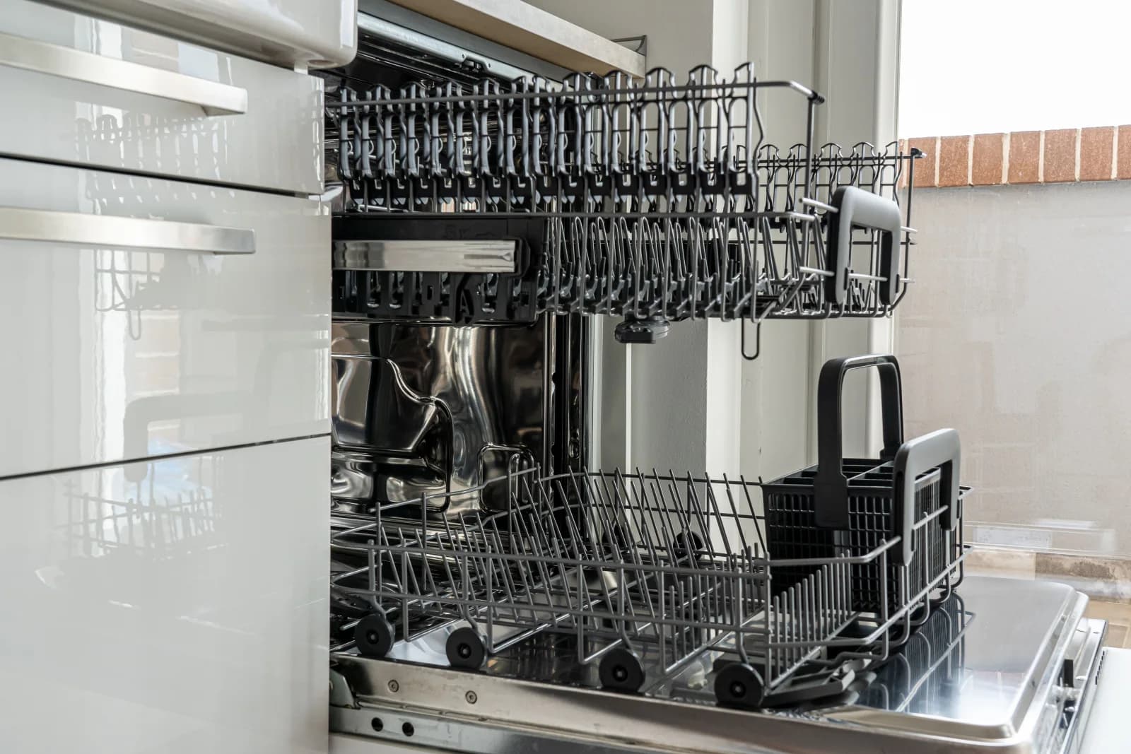 Dishwasher repair near you: open stainless steel dishwasher in a home kitchen