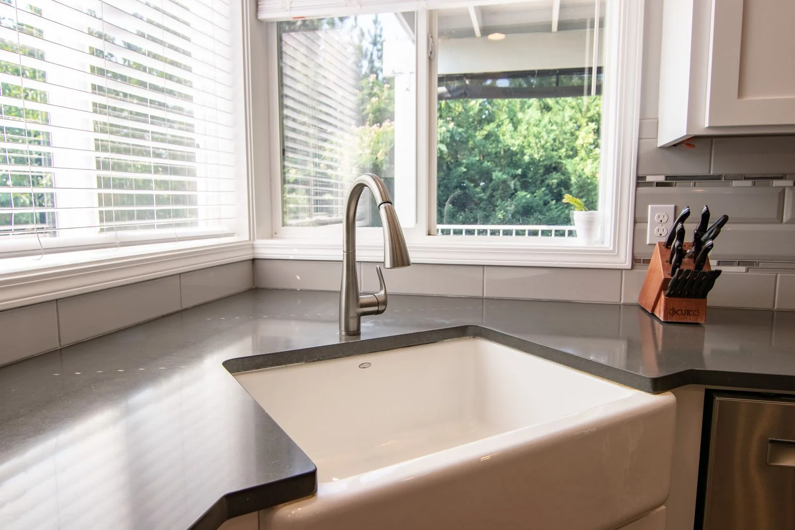 Faucet installation near you: stainless steel pull-down faucet above a white kitchen sink